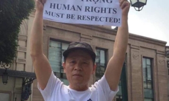 Activist Truong Van Dung holds up a protest sign